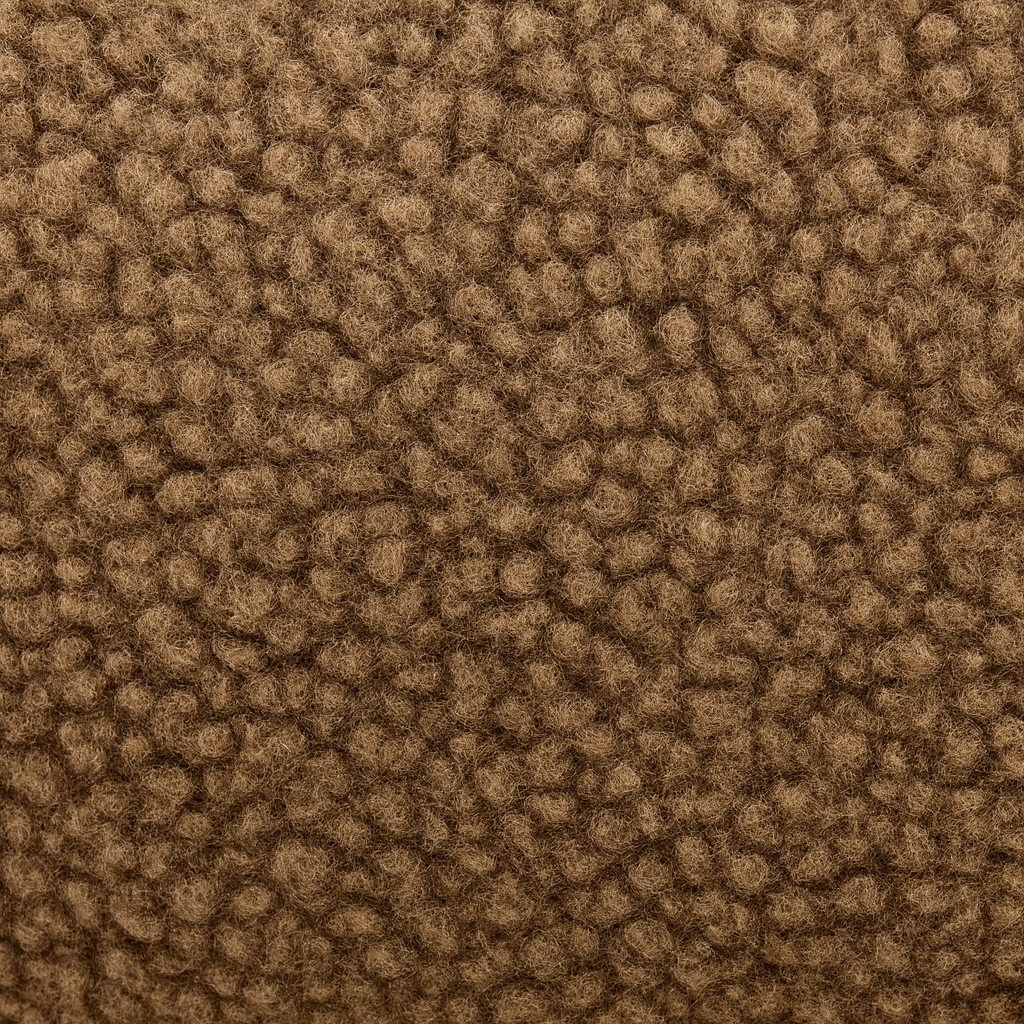 Nahaufnahme des strukturierten Bouclé-Stoffs in warmem Cappuccino-Braun – weiche, robuste Oberfläche für kuschelige Liegeflächen.