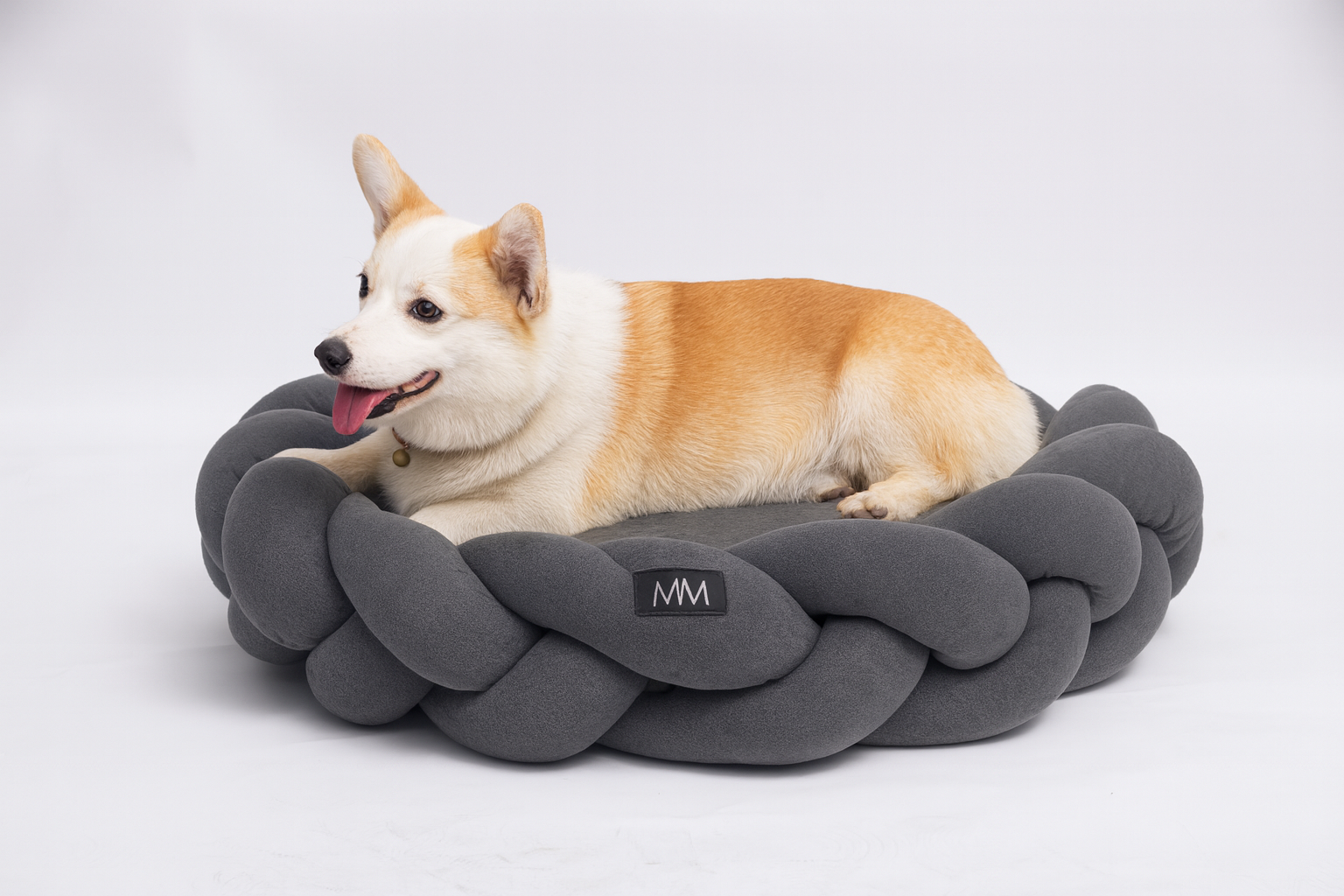 Hundebett geflochten waschbar – Hund liegt bequem im grauen, runden Bett